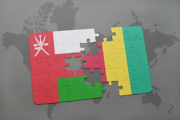 Puzzle con la bandiera nazionale di oman e ghinea su sfondo mappa del mondo . — Foto Stock