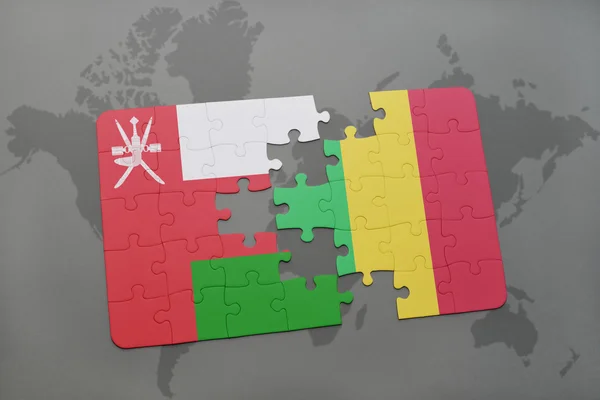 Puzzel met de nationale vlag van Oman en Mali op een wereld kaart achtergrond. — Stockfoto