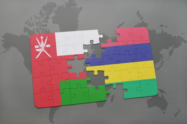 Puzzel met de nationale vlag van Oman en Mauritius op een wereld kaart achtergrond. — Stockfoto