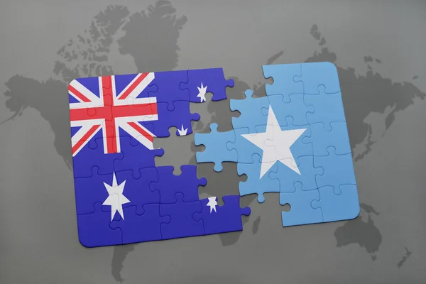 Rompecabezas con la bandera nacional de Australia y Somalia en un mapa del mundo de fondo . — Foto de Stock