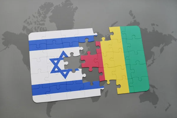 Quebra-cabeça com a bandeira nacional de israel e guineaon um mapa do mundo de fundo . — Fotografia de Stock