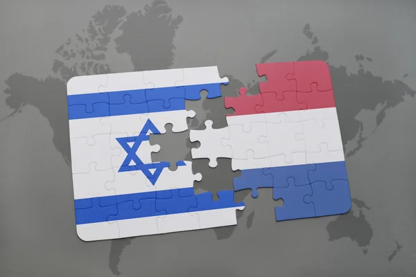 Puzzle avec le drapeau national d'Israël et des Pays-Bas sur un fond de carte du monde . — Photo