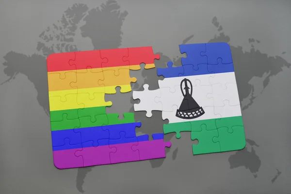 Puzzle with the national flag of lesotho and gay rainbow flag on a world map background. — Stock Photo, Image