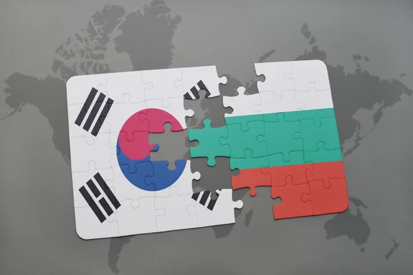 Quebra-cabeça com a bandeira nacional da Coréia do Sul e da bulgaria em um fundo de mapa do mundo . — Fotografia de Stock