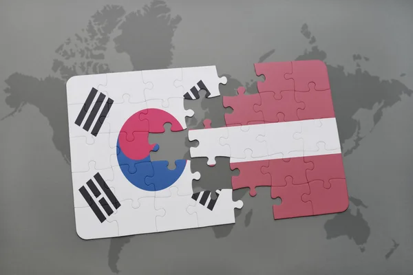Quebra-cabeça com a bandeira nacional da Coréia do Sul e latvia em um fundo de mapa do mundo . — Fotografia de Stock