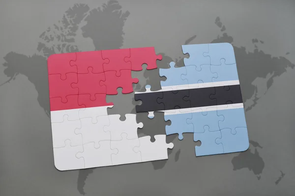 Bir dünya haritası arka plan üzerinde endonezya ve botsvana ulusal bayrağı ile bulmaca. — Stok fotoğraf