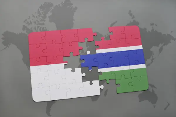 Rompecabezas con la bandera nacional de Indonesia y Gambia en un mapa del mundo fondo . — Foto de Stock