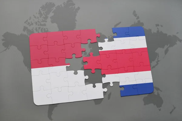 Rompecabezas con la bandera nacional de Indonesia y Costa Rica en un mapa del mundo fondo . — Foto de Stock
