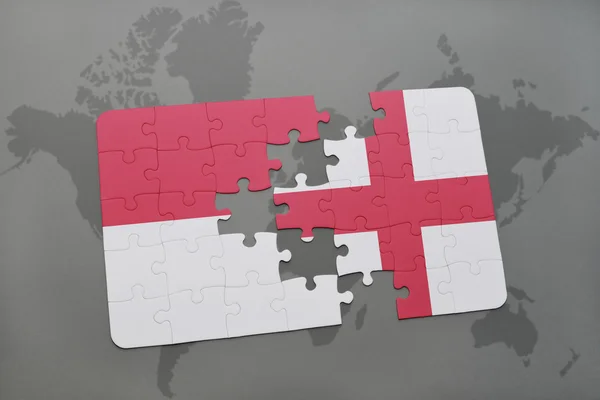 Puzzle s národní vlajkou Indonésie a Anglie na pozadí světové mapy. — Stock fotografie