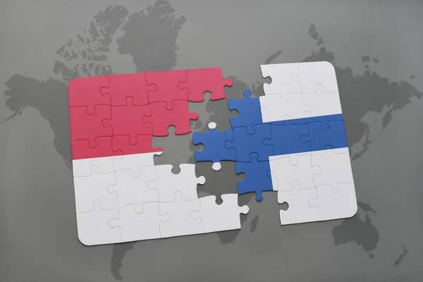 Bir dünya haritası arka plan üzerinde Endonezya ve Finlandiya ulusal bayrağı ile bulmaca. — Stok fotoğraf