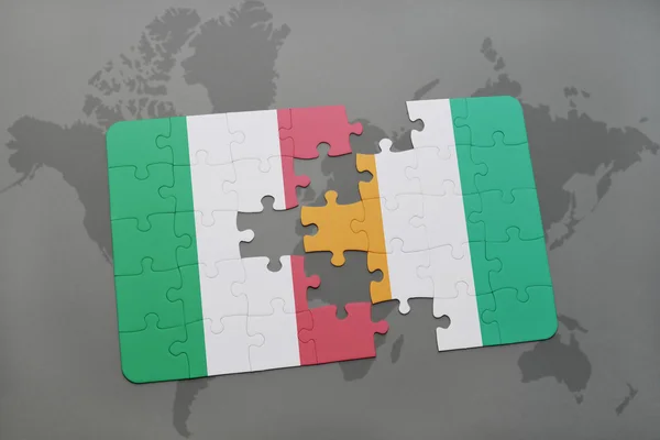 Bir dünya haritası arka plan üzerinde İtalya ve cote divoire ulusal bayrağı ile bulmaca. — Stok fotoğraf