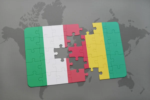Puzzel met de nationale vlag van Italië en Guinee op een wereld kaart achtergrond. — Stockfoto