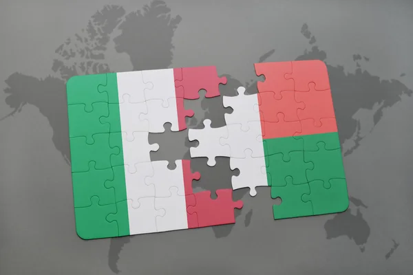 Puzzle con la bandiera nazionale d'Italia e madagvania su uno sfondo mappa del mondo . — Foto Stock