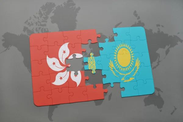Quebra-cabeça com a bandeira nacional de hong kong e kazakhstan em um fundo de mapa do mundo . — Fotografia de Stock