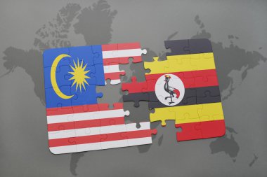 bir dünya haritası arka plan üzerinde malezya ve uganda ulusal bayrağı ile bulmaca.