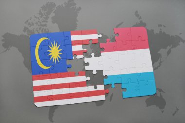 Malezya ve Lüksemburg ulusal bayrak dünya harita arka plan üzerinde ile bulmaca.