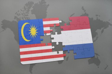 Malezya ve Hollanda ulusal bayrak dünya harita arka plan üzerinde ile bulmaca.