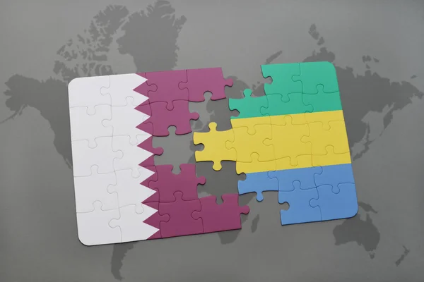 Puzzel met de nationale vlag van Qatar en Gabon op een wereld kaart achtergrond. — Stockfoto