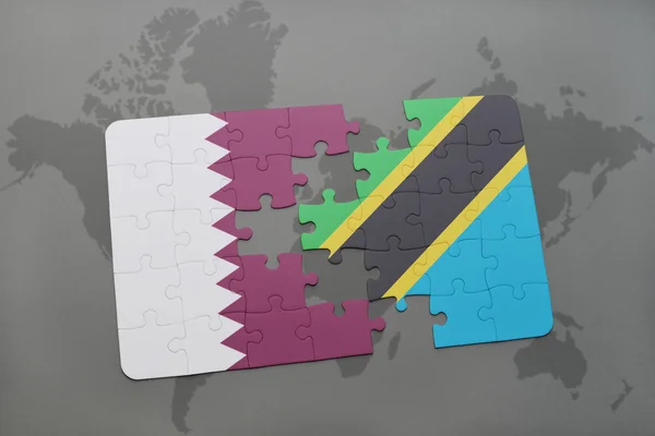 Puzzel met de nationale vlag van Qatar en Tanzania op een wereld kaart achtergrond. — Stockfoto