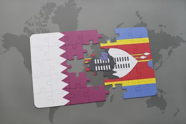 Puzzel met de nationale vlag van Qatar en Swaziland op een wereld kaart achtergrond. — Stockfoto
