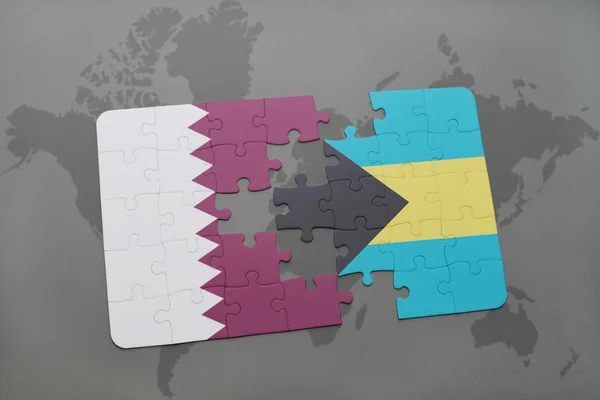 Puzzel met de nationale vlag van Qatar en bahama's op een wereld kaart achtergrond. — Stockfoto