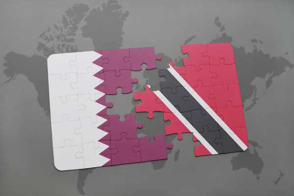 Puzzel met de nationale vlag van Qatar en Trinidad en Tobago op een wereld kaart achtergrond. — Stockfoto