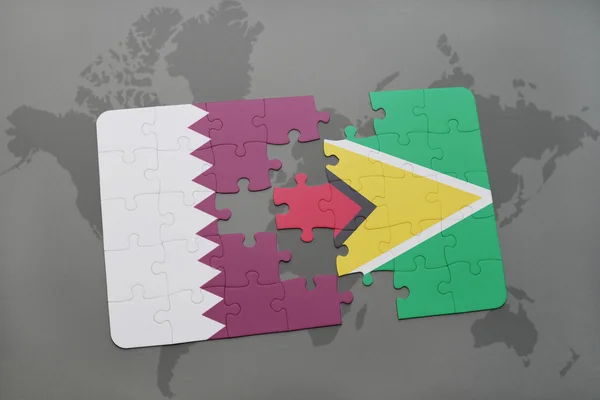 Puzzel met de nationale vlag van Qatar en Guyana op een wereld kaart achtergrond. — Stockfoto