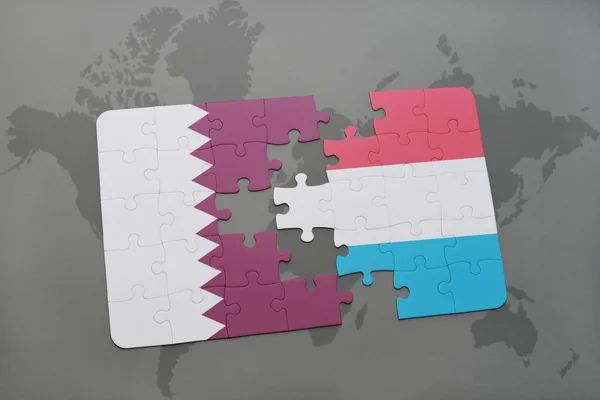 Puzzle with the national flag of qatar and luxembourg on a world map background. — Stock Photo, Image