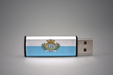 gri arka plan üzerinde san marino ulusal bayrağı ile usb flash sürücü.