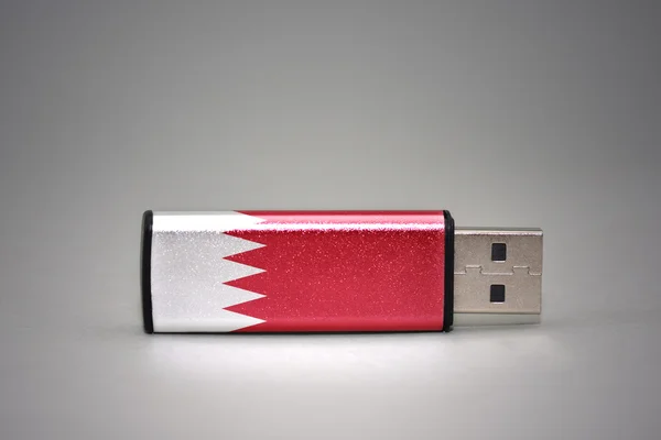 USB-Stick mit der Nationalflagge Bahrains auf grauem Hintergrund. — Stockfoto