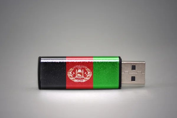 usb flash drive with the national flag of afghanistan on gray background.