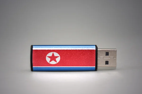 usb flash drive with the national flag of north korea on gray background.