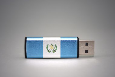 gri arka plan üzerinde guatemala ulusal bayrağı ile usb flash sürücü.