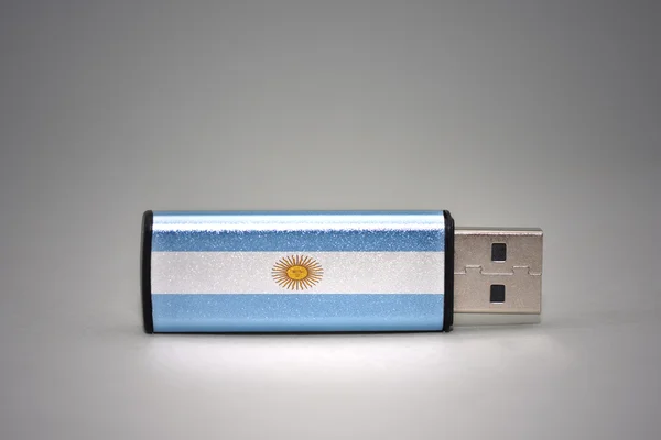 灰色の背景にアルゼンチンの国旗を持つUSBフラッシュドライブ. — ストック写真
