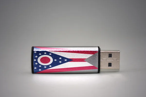 USB-flashstation met de vlag van ohio op een grijze achtergrond. — Stockfoto