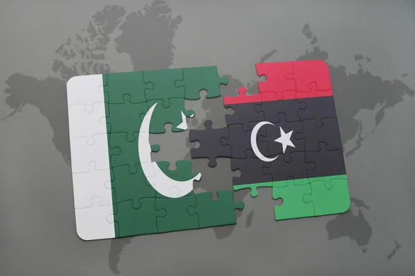 世界地図の背景にパキスタンとリビアの国旗とパズル. — ストック写真