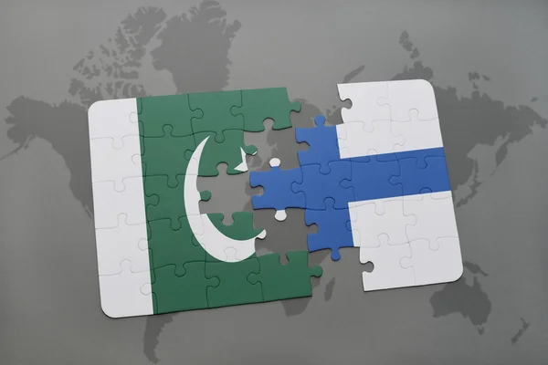 Головоломка с национальным флагом Пакистана и Финляндии на фоне карты мира . — стоковое фото