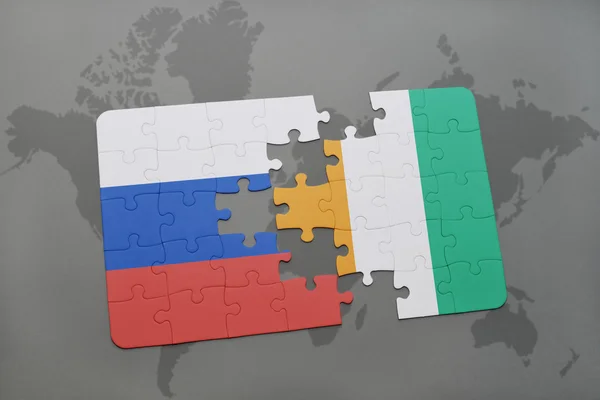 Puzzle avec le drapeau national de la Russie et cote divoire sur fond de carte du monde . — Photo