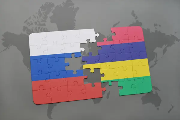 Puzzle avec le drapeau national de la Russie et mauritius sur un fond de carte du monde . — Photo