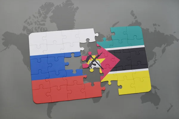 Puzzel met de nationale vlag van Rusland en mozambique op de achtergrond van een wereld kaart. — Stockfoto