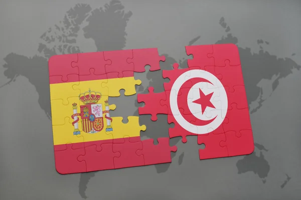 Puzzle with the national flag of spain and tunisia on a world map background. — Stock Photo, Image
