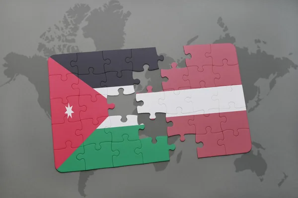 Rompecabezas con la bandera nacional de Jordania y Latvia en un fondo mapa del mundo . —  Fotos de Stock