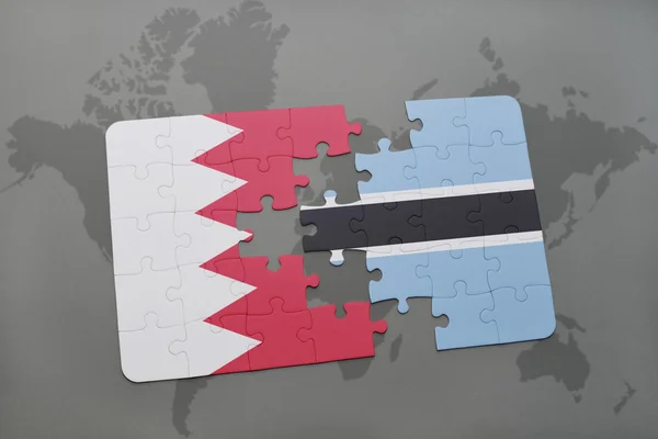 Puzzle avec le drapeau national du bahreïn et du botswana sur fond de carte du monde . — Photo