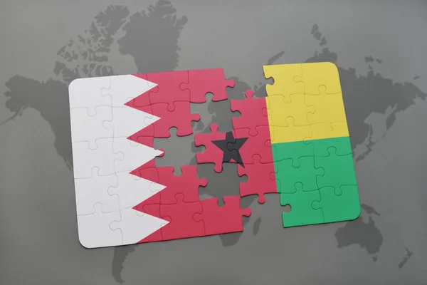 Puzzel met de nationale vlag van Bahrein en Guinee-Bissau op een wereld kaart achtergrond. — Stockfoto