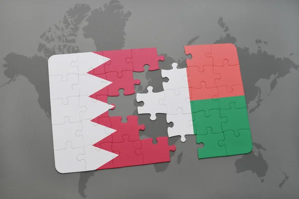 Pussel med den nationella flaggan i Bahrain och Madagaskar på en världskarta bakgrund. — Stockfoto