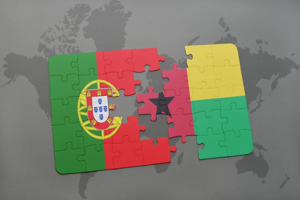Quebra-cabeça com a bandeira nacional de portugal e guiné bissau sobre um mapa mundial de fundo . — Fotografia de Stock