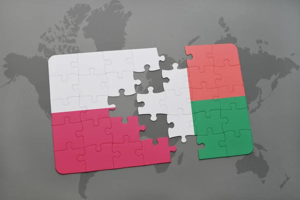世界地図の背景にポーランドとマダガスカルの国旗とパズル。3Dイラスト — ストック写真