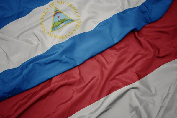 Κυματίζει Πολύχρωμη Σημαία Της Ινδονησίας Και Εθνική Σημαία Της Νικαράγουα — Φωτογραφία Αρχείου