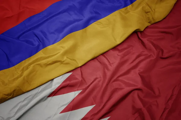 waving colorful flag of bahrain and national flag of armenia. macro