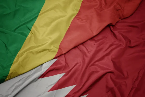 waving colorful flag of bahrain and national flag of republic of the congo. macro